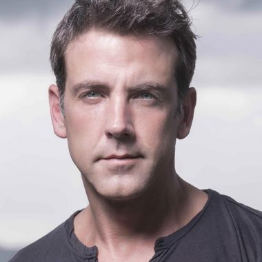 Retrato del actor Carlos Ponce con cielo gris